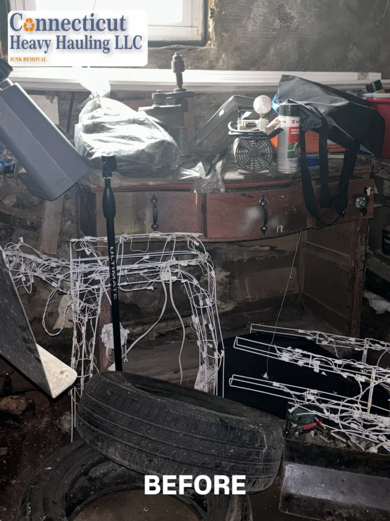 Before photo of cluttered garage with furniture and tools cleaned by Connecticut Heavy Hauling LLC