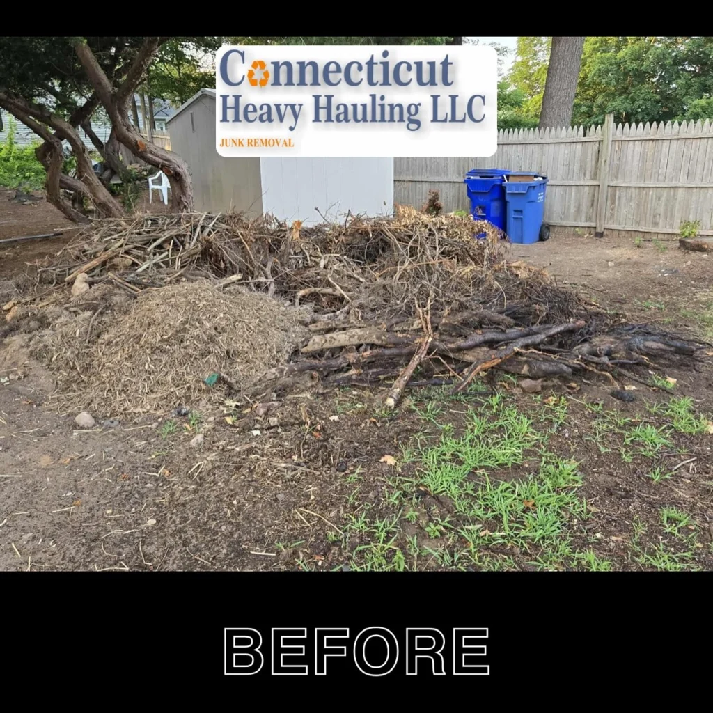 Before photo: cluttered backyard with wood piles, pallets, and construction debris cleared by Connecticut Heavy Hauling LLC